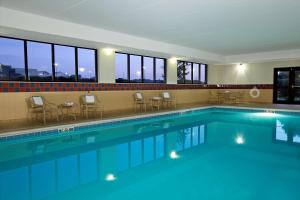a large swimming pool with chairs and tables and windows at Hampton Inn & Suites Madisonville in Madisonville