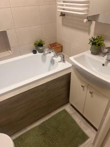 a bathroom with a bath tub and a sink at Apartament Leszczyna in Olsztyn