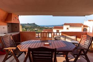 a patio with a table and chairs on a balcony at trilocale con piscina in Arzachena
