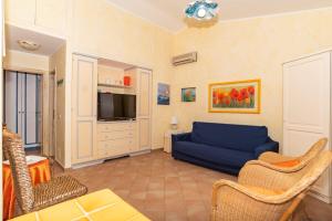 uma sala de estar com um sofá azul e uma televisão em trilocale con piscina em Arzachena