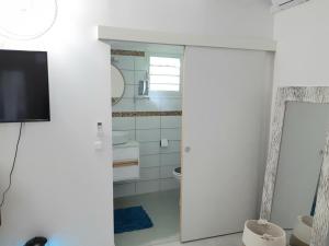 a bathroom with a toilet and a tv on a wall at Appartement Fleur De Lys in Fort-de-France +47 photos