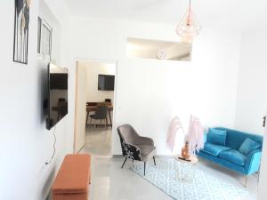 a living room with a blue couch and a chair at Appartement Fleur De Lys in Fort-de-France