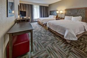 a hotel room with two beds and a desk at Hampton Inn Newberry Opera House in Newberry +17 photos