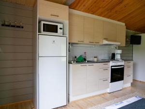 a kitchen with a white refrigerator and a microwave at Tenon maisemamökit in Utsjoki +7 photos