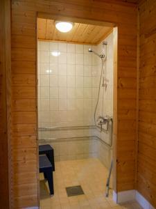 een badkamer met een douche en een glazen deur bij Tenon maisemamökit in Utsjoki