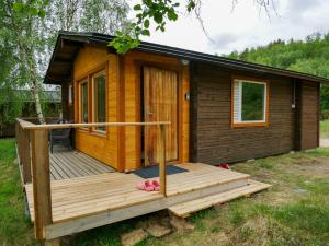 een houten hut met een veranda en een terras bij Tenon maisemamökit in Utsjoki