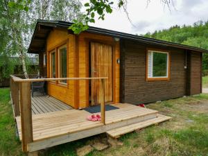 a wooden cabin with a porch and a deck at Tenon maisemamökit in Utsjoki