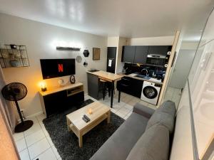 a living room with a couch and a table at Studio Pessac Centre Tram & Parking in Pessac