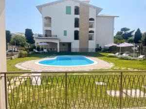 une villa avec une piscine en face d'un bâtiment dans l'établissement Homiday - Appartamento Smeraldo, à Pineto