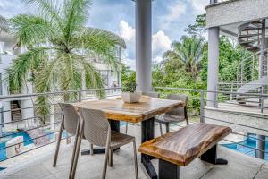 a patio with a wooden table and chairs on a balcony at Hermosa Wave D1 & D2 in Playa Hermosa