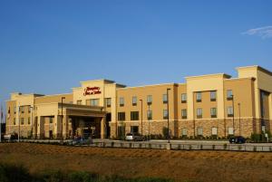 a large building with cars parked in front of it at Hampton Inn & Suites Center in Center