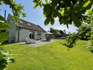 a house with a yard with chairs and a patio at Yew Tree Cottage in Shepton Mallet
