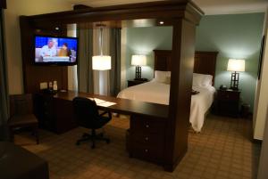 a hotel room with a bed and a desk and a television at Hampton Inn & Suites Center in Center