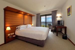 Cette chambre comprend un grand lit et un bureau. dans l'établissement Hilton Noumea La Promenade Residences, à Nouméa