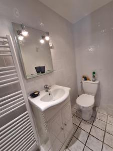 ein weißes Bad mit einem Waschbecken und einem WC in der Unterkunft Tanzanite - 6 couchages in Archigny