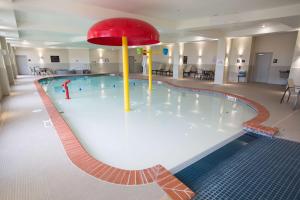 a swimming pool with a red umbrella in the middle at Hampton Inn & Suites Oklahoma City Airport in Oklahoma City