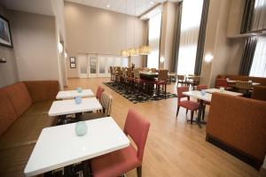 a restaurant with tables and chairs and a dining room at Hampton Inn & Suites Oklahoma City Airport in Oklahoma City