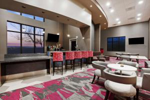 a lobby with a bar with chairs and tables at Hampton Inn & Suites Oakland Airport-Alameda in Alameda