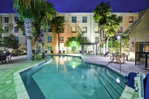 una piscina frente a un edificio por la noche en Homewood Suites by Hilton Ocala at Heath Brook, en Ocala