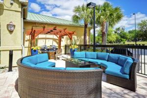 un patio con sofá y sillas azules y cenador en Homewood Suites by Hilton Ocala at Heath Brook, en Ocala
