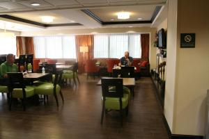 two people sitting at tables in a restaurant at Hampton Inn Olive Branch in Olive Branch