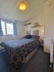 1 dormitorio con 1 cama con edredón azul en The Summer House en Heysham