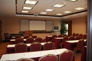 a conference room with tables and chairs and a whiteboard at Hampton Inn Olive Branch in Olive Branch