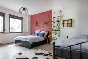 een slaapkamer met 2 bedden en een roze muur bij Altstadtjuwel mit Loft Charme - Netflix in Koblenz