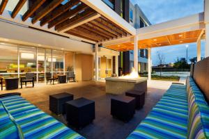 an outdoor patio with two beds and a fireplace at Home2 Suites By Hilton Omaha West in Omaha