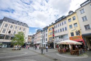 eine Stadtstraße mit Gebäuden und Menschen, die herumlaufen in der Unterkunft Altstadtjuwel mit Loft Charme - Netflix in Koblenz