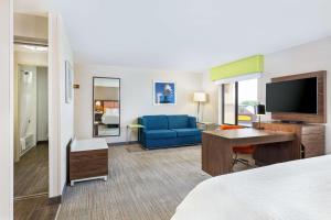 a hotel room with a bed and a blue couch at Newly Renovated Hampton Inn Omaha West Lakeside in Omaha