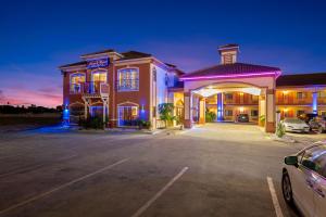 un edificio con un'auto parcheggiata in un parcheggio di Casa Rosa Inn a Port Isabel