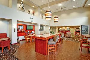 Hampton Inn & Suites by Hilton Barrie في باري: غرفة كبيرة مع بار وبعض الكراسي