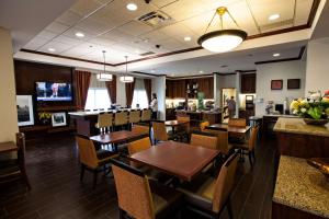 un restaurant avec des tables et des chaises en bois ainsi qu'un bar dans l'établissement Hampton Inn by Hilton Napanee, à Napanee