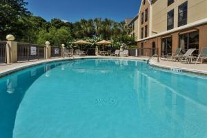 a large blue swimming pool with chairs and umbrellas at Hampton Inn Pawleys Island in Pawleys Island