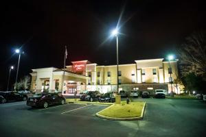 une station-service de nuit avec des voitures garées dans un parking dans l'établissement Hampton Inn - Monticello, à Monticello