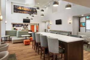 a lobby with a bar with chairs and a couch at Hampton Inn & Suites Pine Bluff in Pine Bluff