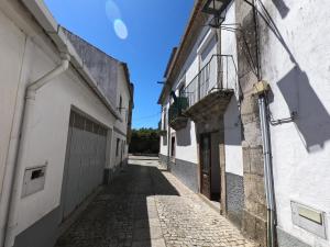 an alley in an old town with a blue sky at Albergue Santiago de Caminha in Caminha