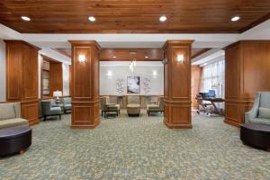 un vestíbulo con una sala de espera con sillas y mesas en Hampton Inn West Palm Beach-Lake Worth-Turnpike, en Lake Worth