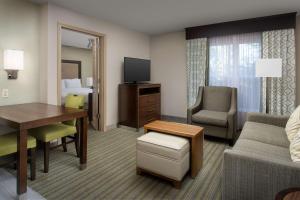 a hotel room with a desk and a living room at Homewood Suites Hillsboro Beaverton in Beaverton