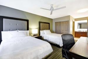 una camera d'albergo con due letti e un tavolo con sedia di Homewood Suites Hillsboro Beaverton a Beaverton