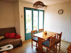 ein Wohnzimmer mit einem Tisch und einem Sofa in der Unterkunft Charmant T2 climatisée au coeur du village in Saint-Mandrier-sur-Mer