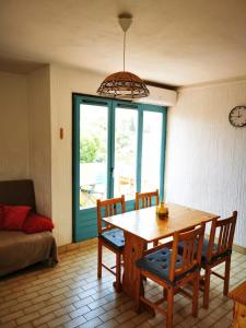 ein Esszimmer mit einem Tisch, Stühlen und einem Fenster in der Unterkunft Charmant T2 climatisée au coeur du village in Saint-Mandrier-sur-Mer