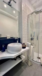 y baño con lavabo blanco grande y ducha. en Sea Glimpse Studio - Santa Lucia, en Nápoles