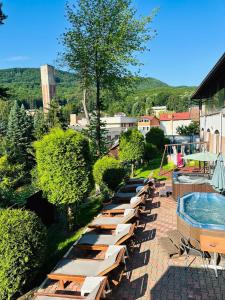 a row of lounge chairs next to a swimming pool at Hotel Suprem in Băile Olăneşti