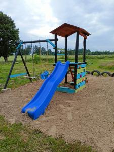 plac zabaw z niebieską zjeżdżalnią na polu w obiekcie Świerkowe Siedlisko w Węgorzewie
