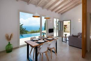 a dining room with a table and a view of the ocean at Terra villa by PaxosRetreats in Lákka