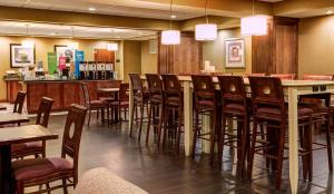 a restaurant with a bar with chairs and tables at Hampton Inn Pendleton in Pendleton