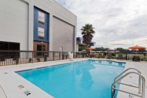 una piscina en un hotel con mesas y sombrillas en Hampton Inn Perry en Perry