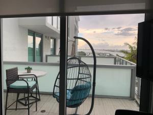 a balcony with a rattan chair and a table at Luxury Oceanview Studio at Miami Design District in Miami